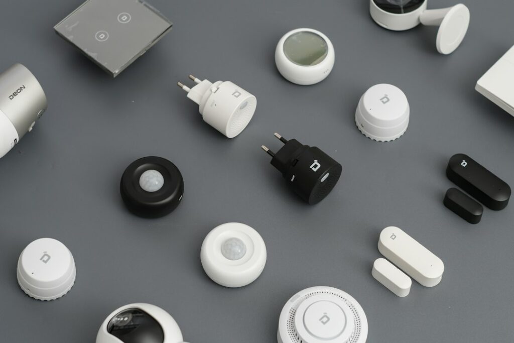 Wall-mounted motion sensor overlooking a residential hallway with stairs and a closed entry door.