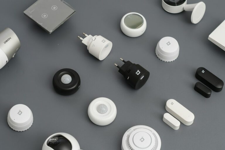 Wall-mounted motion sensor overlooking a residential hallway with stairs and a closed entry door.