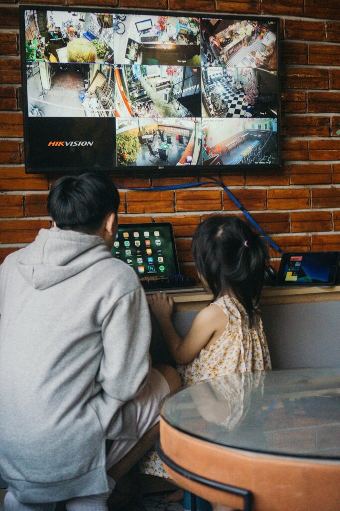 A homeowner reviews an alarm panel while a monitoring operator handles an alert on a computer.